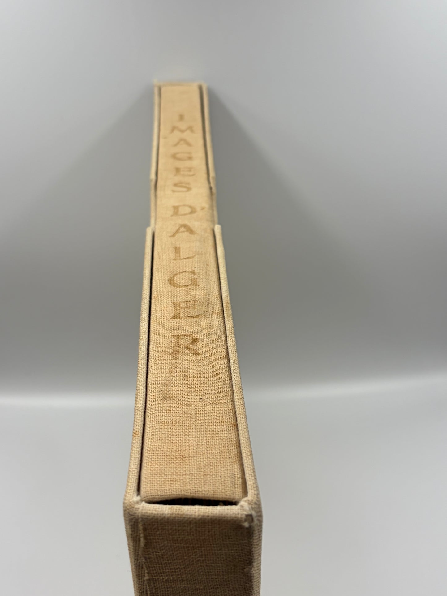 A close-up shot of hardcover portfolio spine, showing the title 'IMAGES DALGER' on original 1948 cloth binding against a neutral gray background.