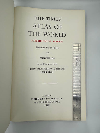 Title page of 'The Times Atlas of the World, Comprehensive Edition' with a ruler on top. 