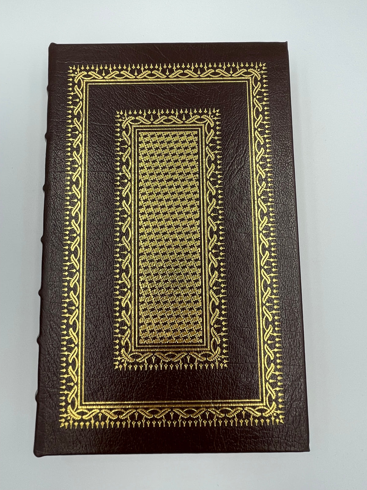 Leather bound book cover adorned with gold gilt decor.