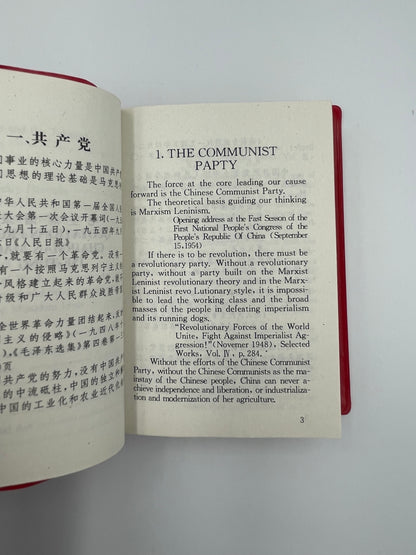 Open pages in English and Chinese script from "Quotations From Chairman Mao Tse-Tung" aka "The Little Red Book". 