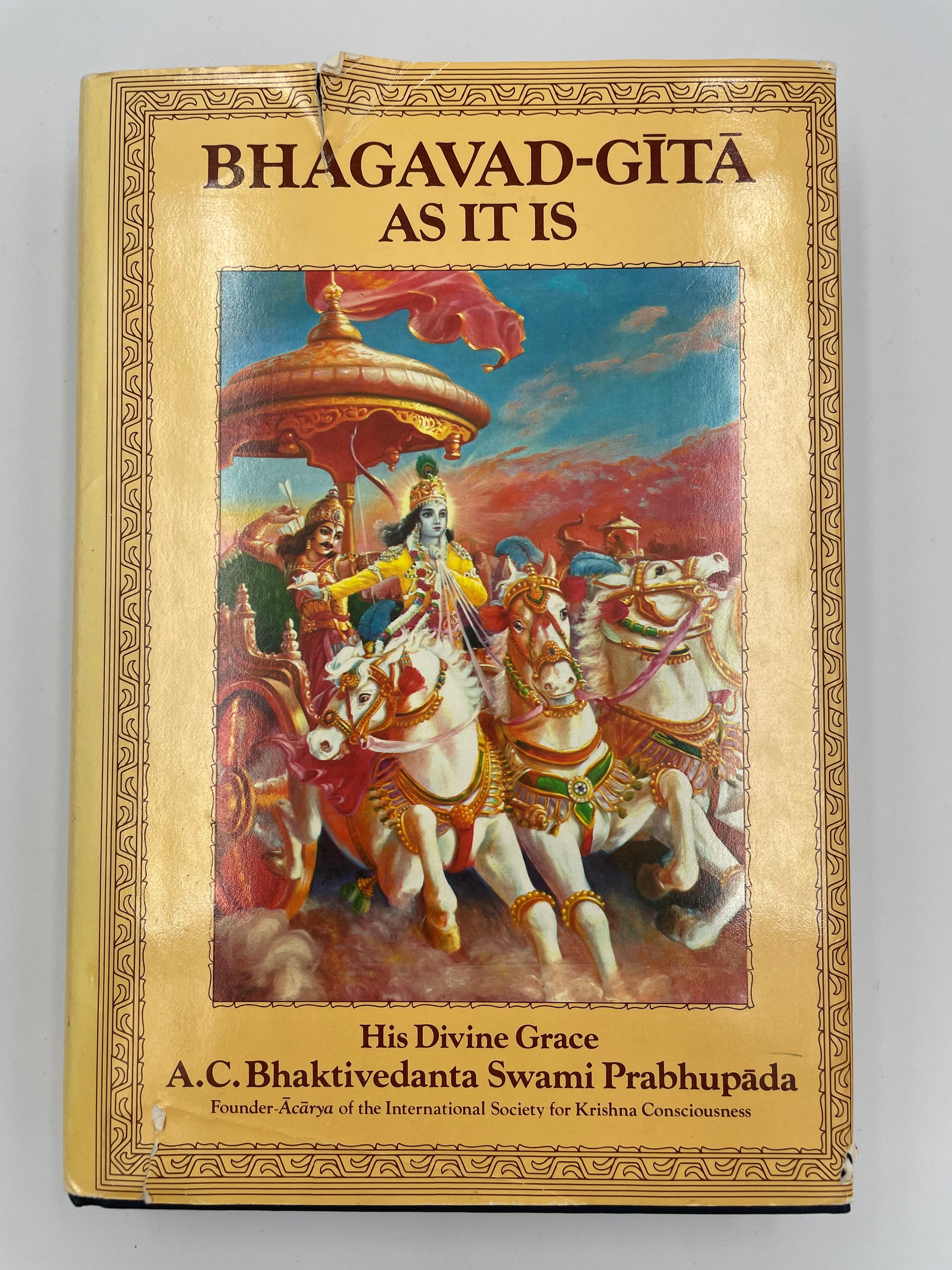 Book titled 'Bhagavad-Gita As It Is' with a colorful illustration on the cover.