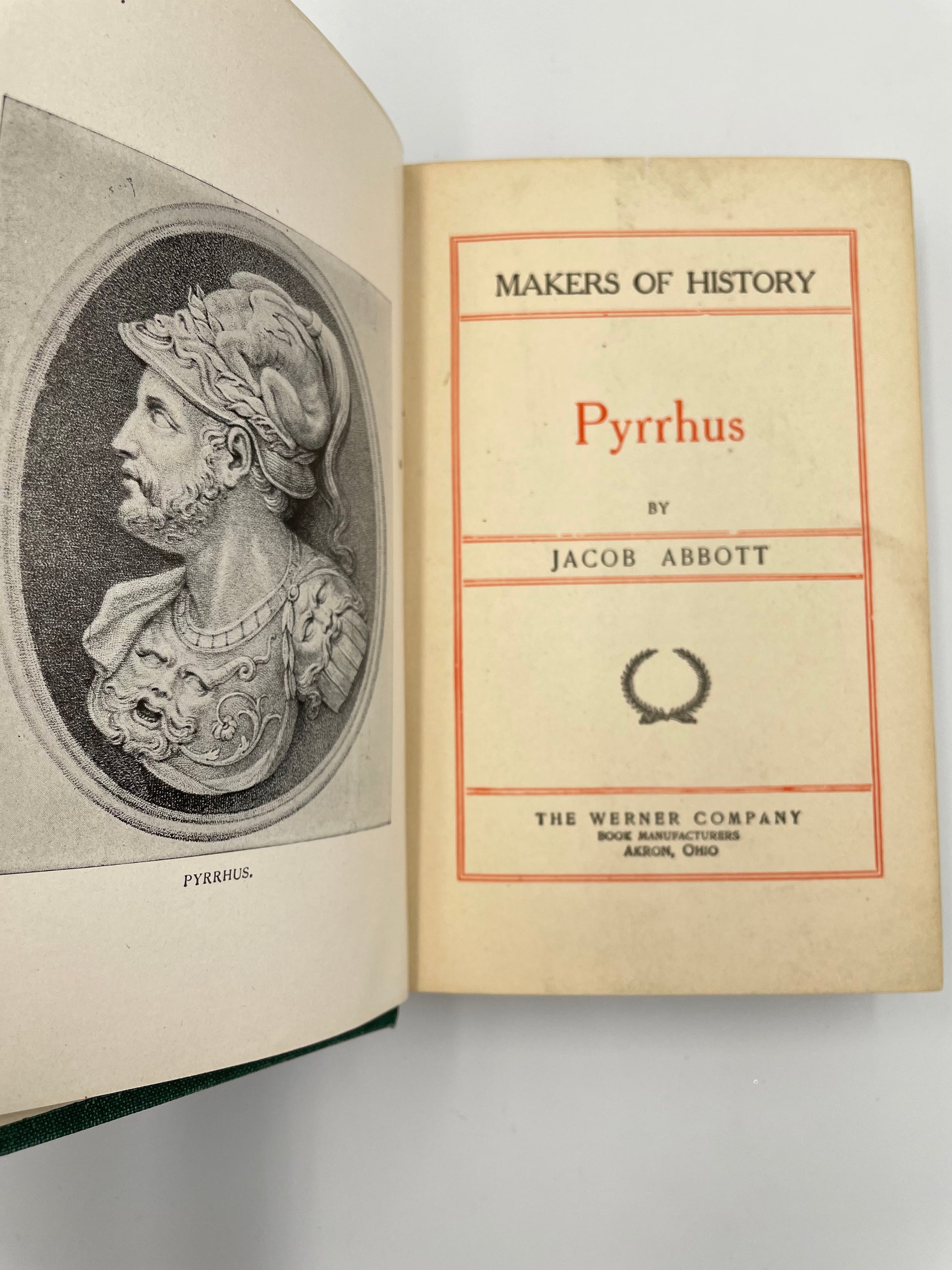 Open book with an image of a bust of Pyrrhus and title page of 'Pyrrhus' by Jacob Abbott.