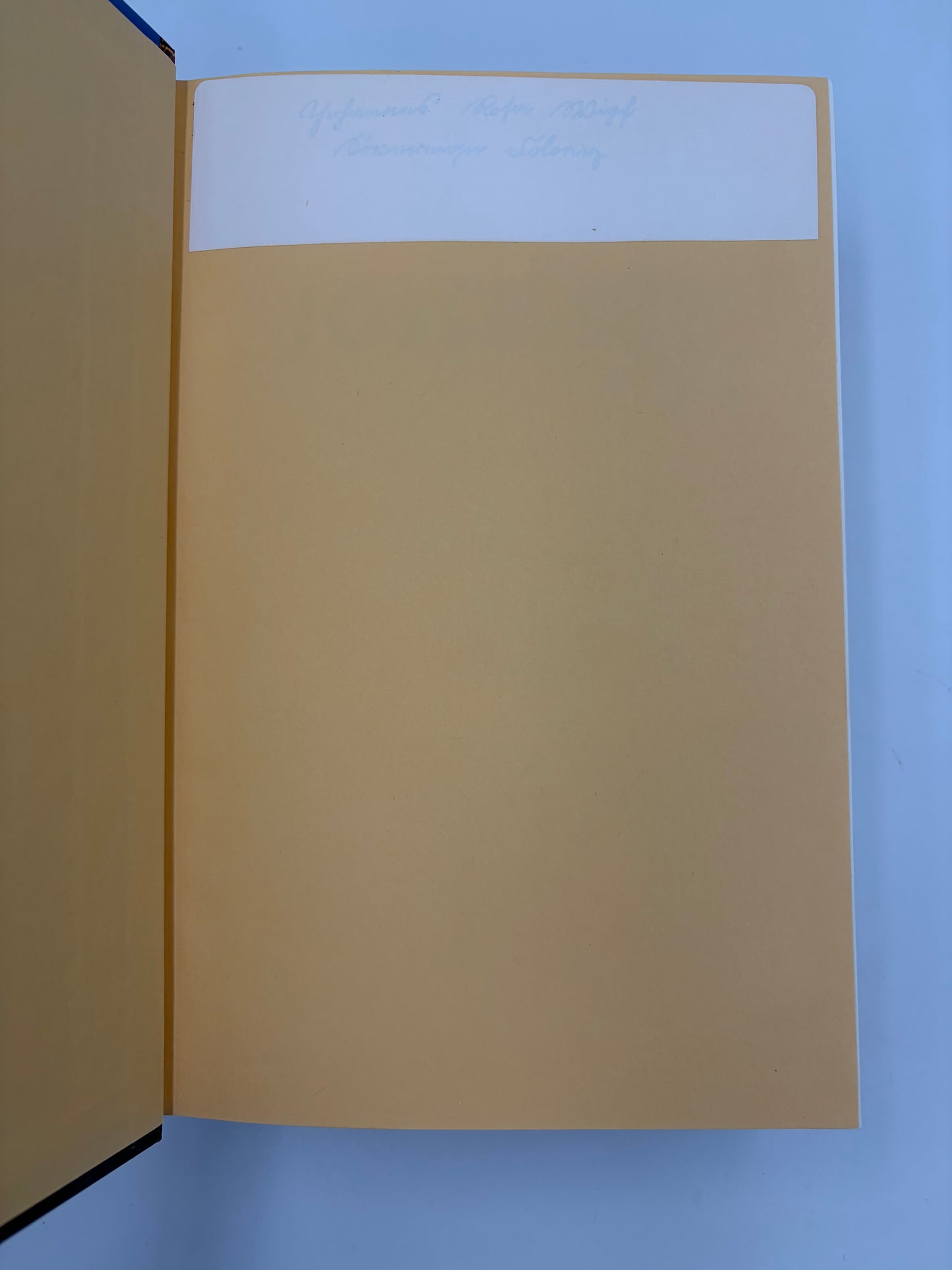 Open book with a plain beige page on a blue background.