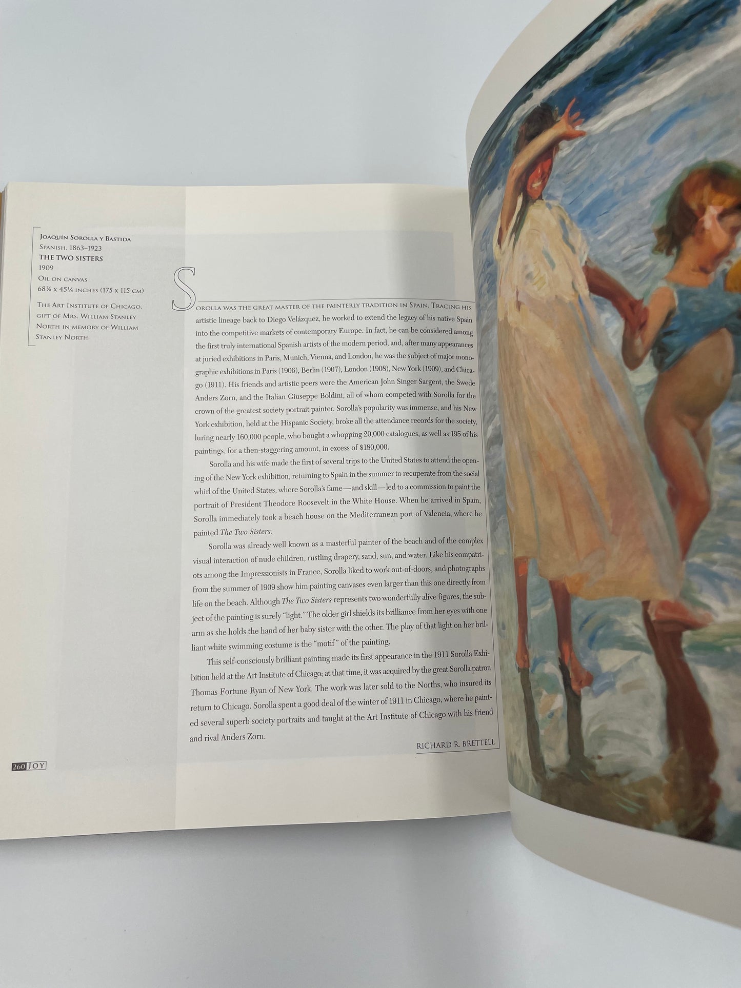 Open book with a painting on the right page and text on the left page.
