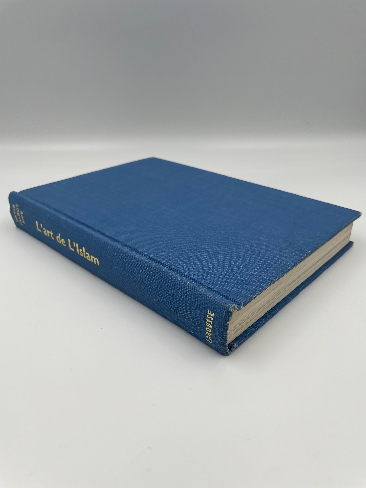 Blue book entitle me L’Art de L’Islam with gold gilt on a white background.