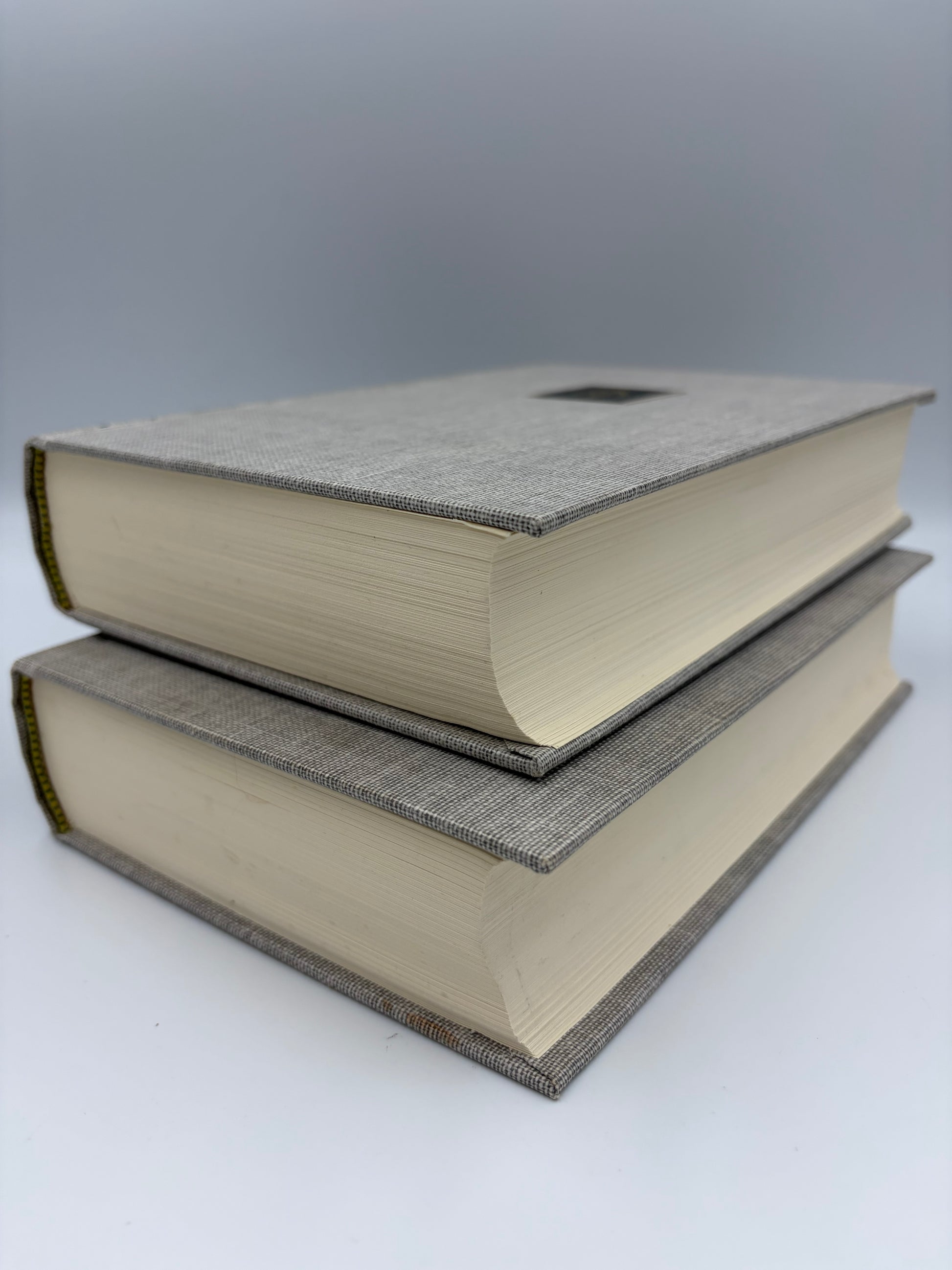 Two stacked books with textured covers on a white background.