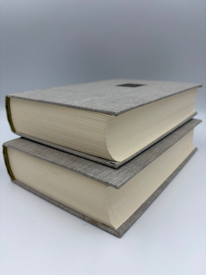 Two stacked books with textured covers on a white background.