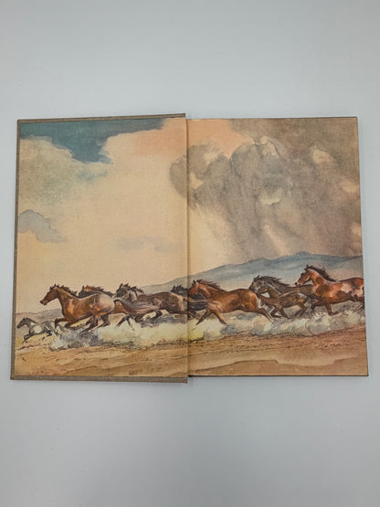 Inside cover pages of an illustrated painting depicting horses running on a landscape with a mountainous background from the book, 'The Red Pony' by John Steinbeck. 