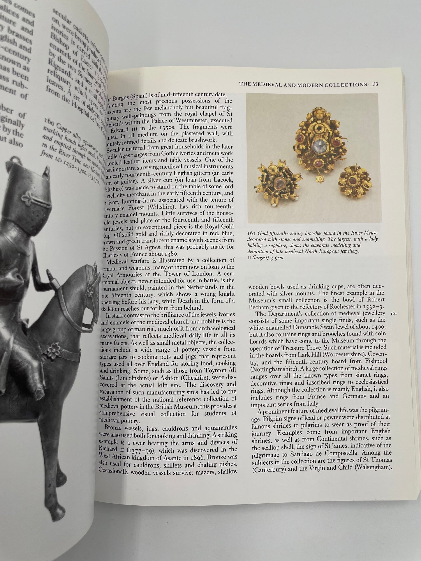 Open book with illustrations of jewelry and a knight on a horse, on a white background